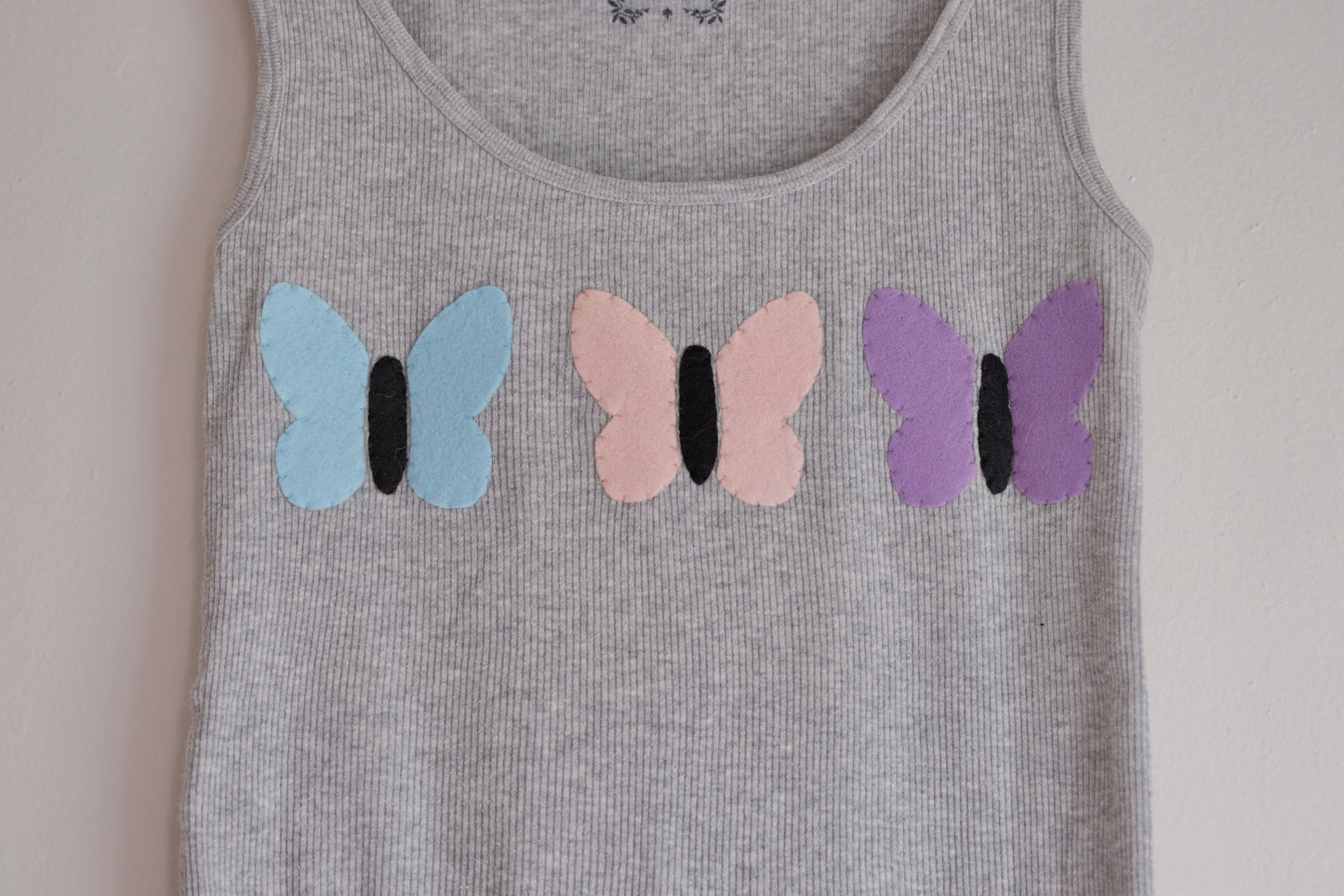 gray tank with butterflies